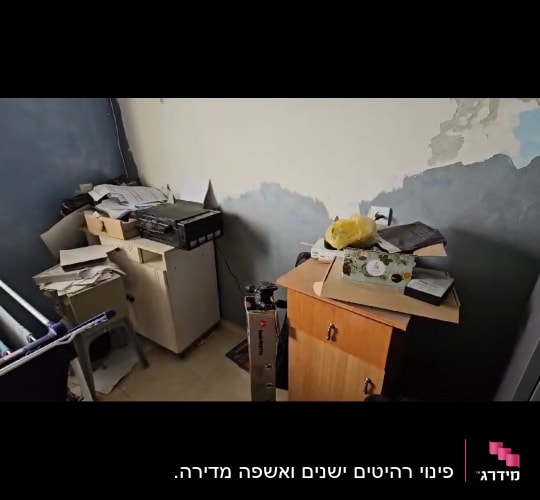 חדר מבולגן עם קופסאות, ניירות וארון קטן